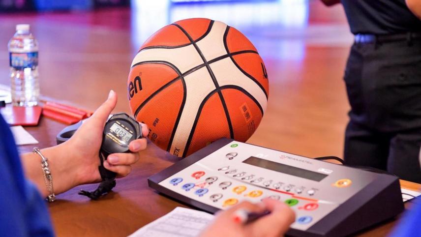 Photo d'un chronomètre et d'un ballon de basket pour la bonne gestion d'un match de basket